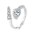A silver-toned open ring with a large heart-shaped clear gemstone and smaller clear stones along the split band.