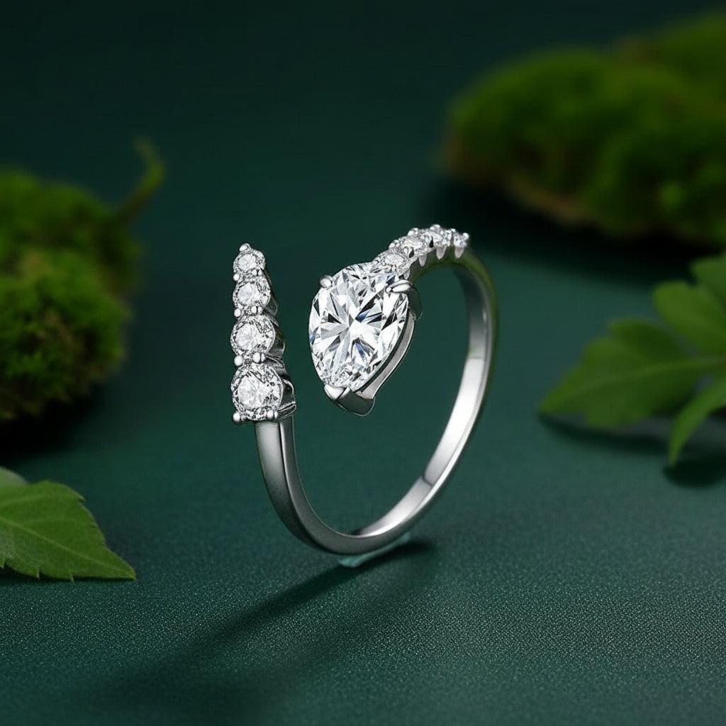 1.5CT Pear-Cut Moissanite Adjustable Ring with a dark green background.