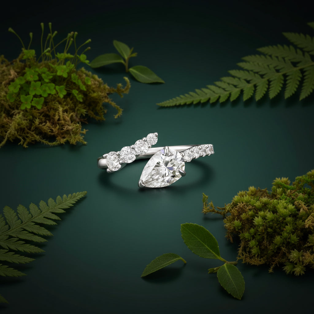 A silver diamond ring with a marquise-cut center stone and smaller diamonds along the band, placed on a dark green background.