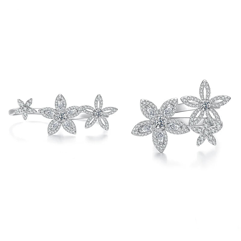 A pair of silver-toned flower cluster rings shown on a white background, labeled 'Open' and 'Close' to demonstrate the setting. The rings are paved with small clear stones.