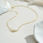 Gold necklace on a white surface