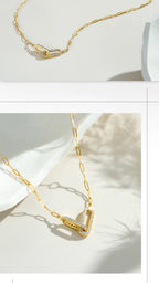 Gold necklace with a geometric pendant on a white background