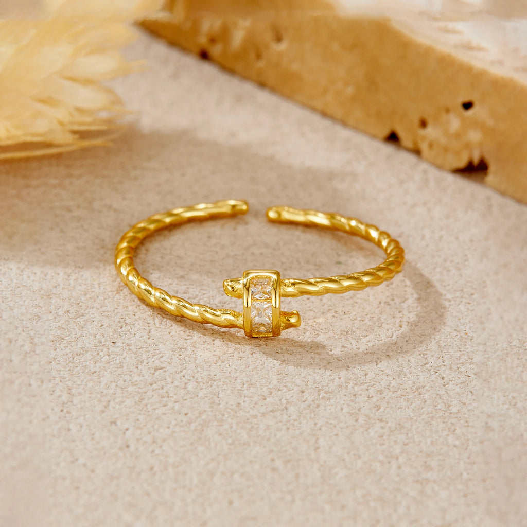 Gold ring with a diamond on a sandy background
