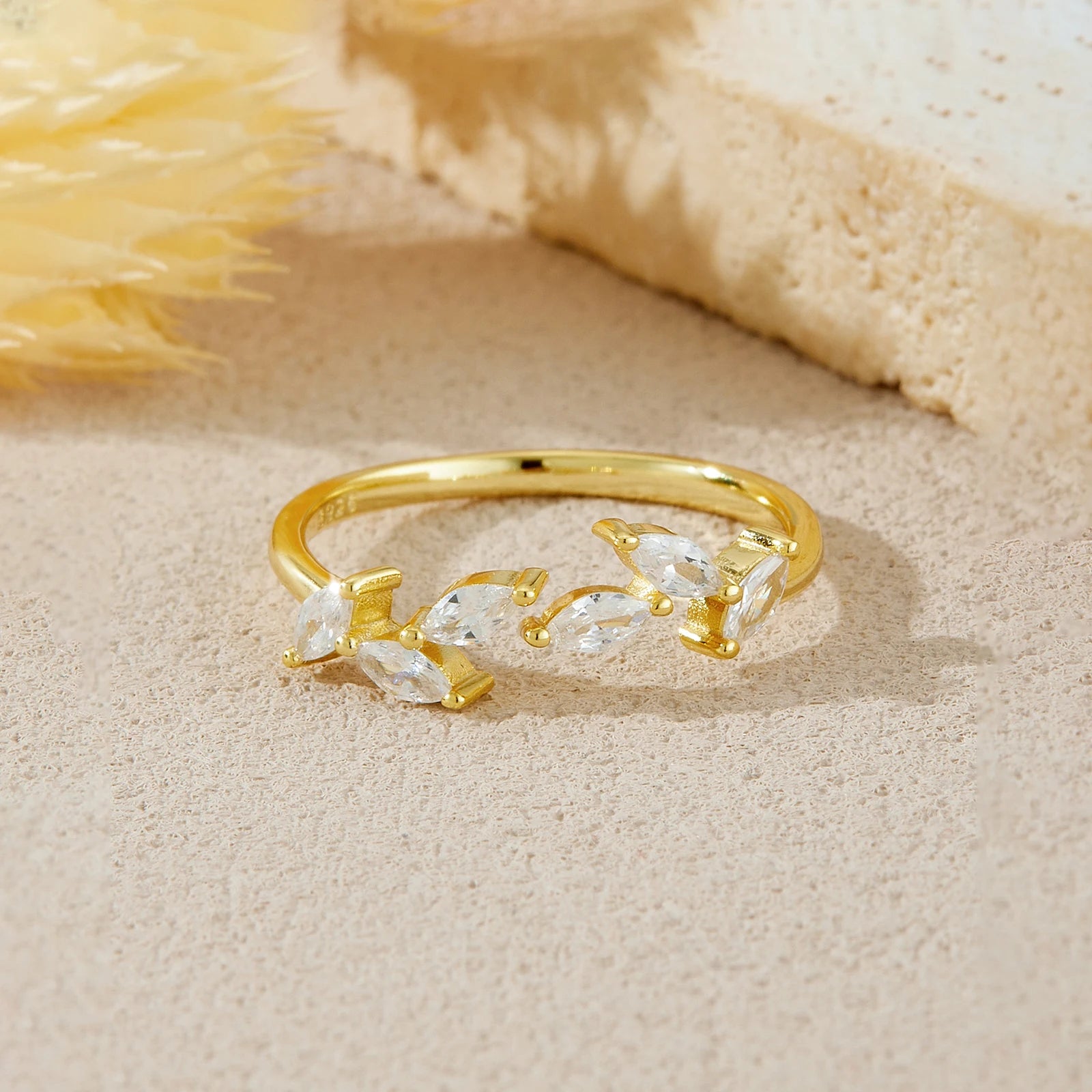 Gold ring with clear stones on a beige surface