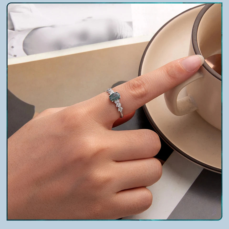Hand with a ring holding a teacup, with a light blue border