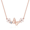 Rose gold butterfly and flower necklace on a white background
