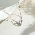 Silver necklace with a V-shaped pendant on a light background