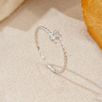 Silver ring with a diamond on a beige fabric background