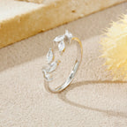 Silver ring with marquise-shaped stones on a sandy surface