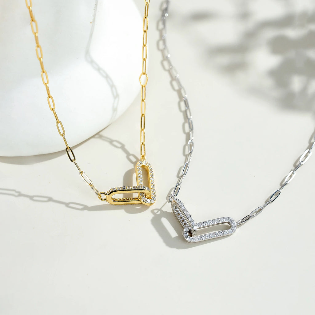 Two gold necklaces with diamond accents on a white background