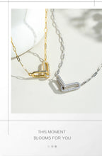 Two necklaces, one gold and one silver, on a light background with text 'This moment blooms for you'.